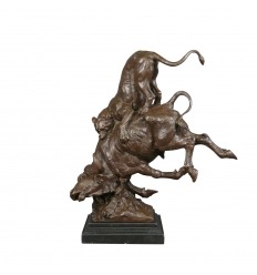 Estatua de bronce de un puma atacando a un toro.